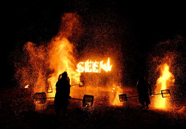 Fire performers spelling out the word SEEN in flames during a Club SEEN after-dark show